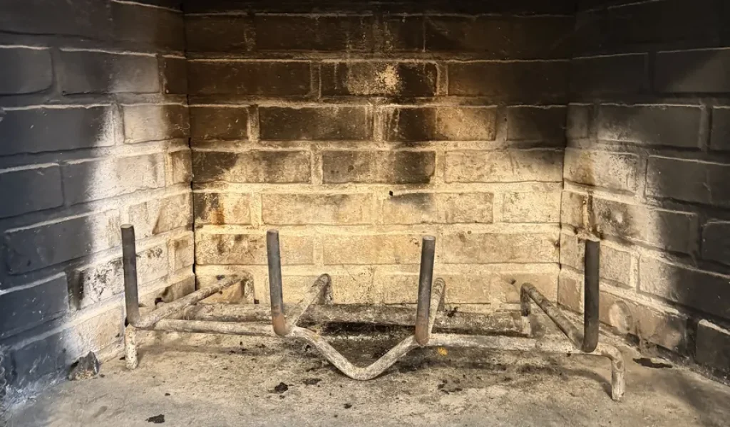 Creosote-stained fireplace firebox before chimney cleaning