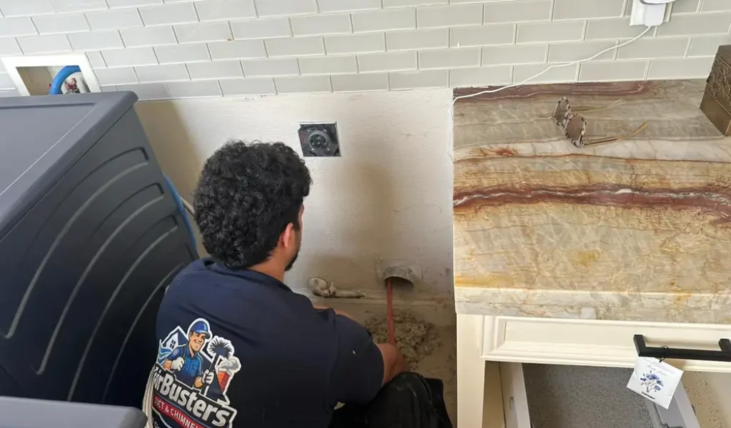 Air Busters technician cleaning a home air duct in the Dallas-Fort Worth area