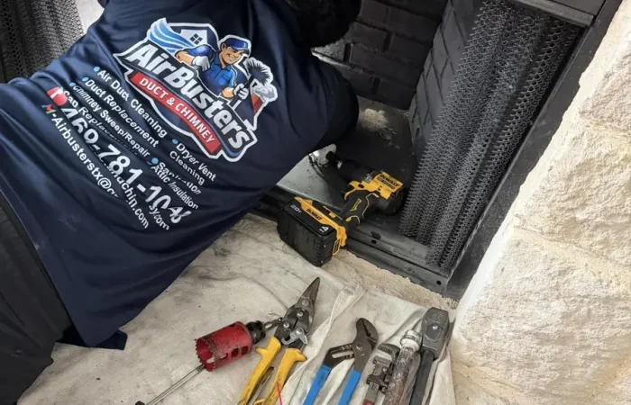 Air Busters technician cleaning a fireplace and chimney in a DFW home